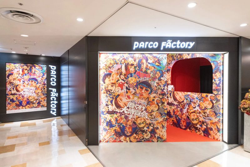 パルコファクトリーの入り口。壁には顔写真がコラージュされたポスターが貼られており、入り口のアーチも同様のデザインで彩られている。