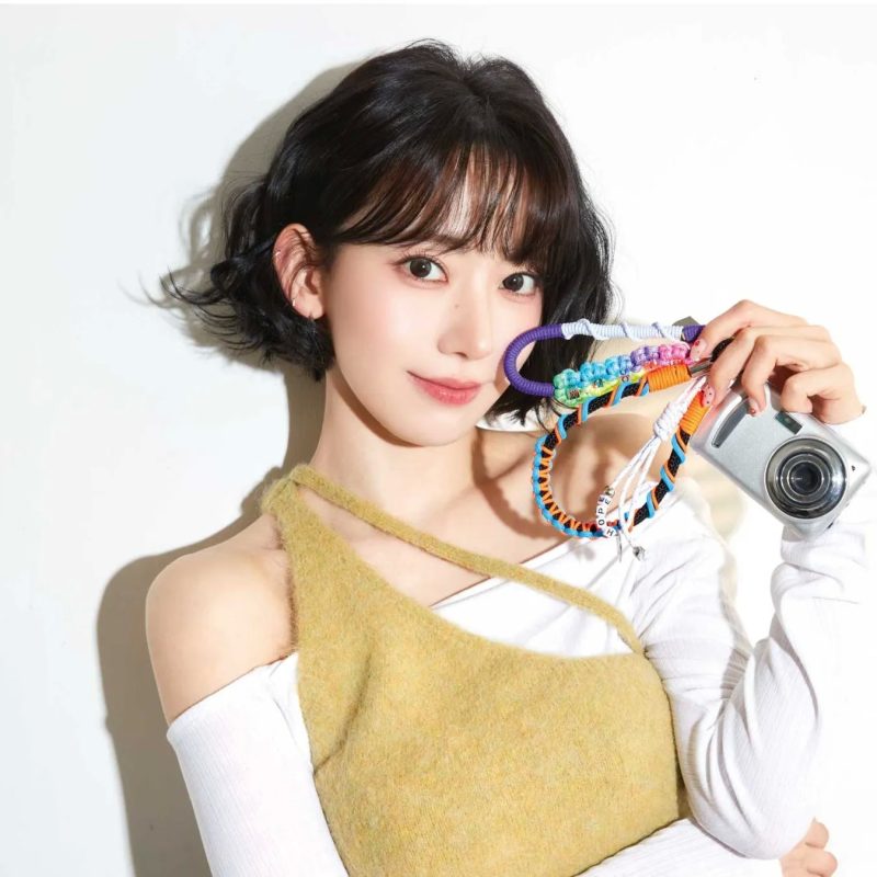 女性がカメラを持って微笑んでいる写真