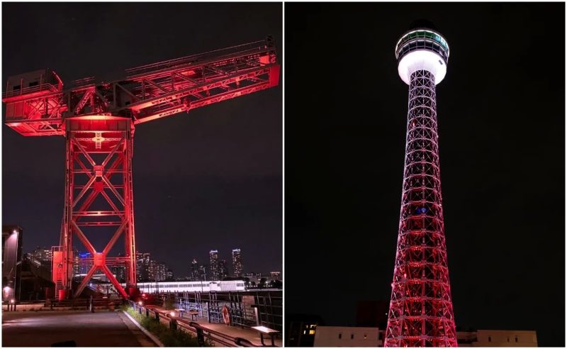 夜にライトアップされた赤いクレーンとタワーの画像