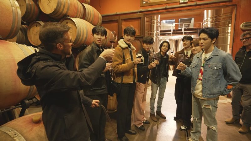 ワインセラーでワインを試飲する男性グループ